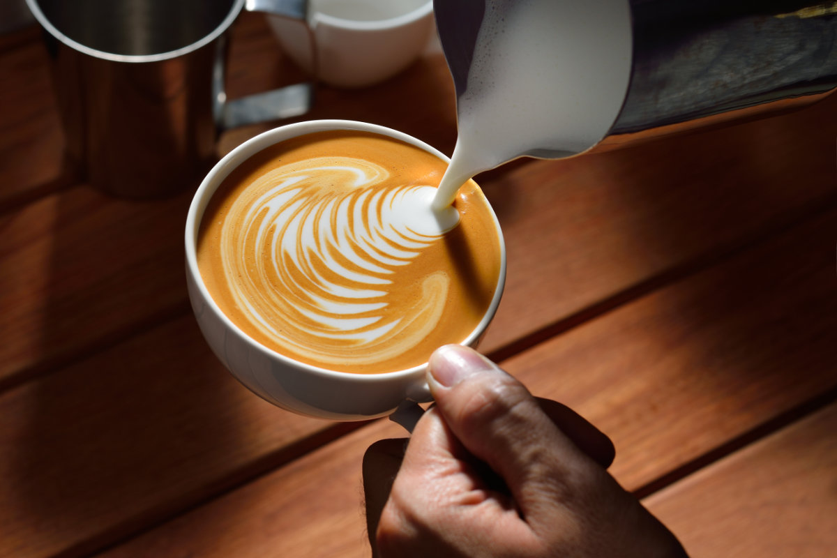 Barista serving a latte